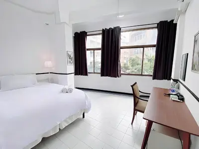 a bedroom with a bed and a desk with a computer at XX GO INN MRT Hua Lamphong - วัดไตรมิตร in Samphanthawong