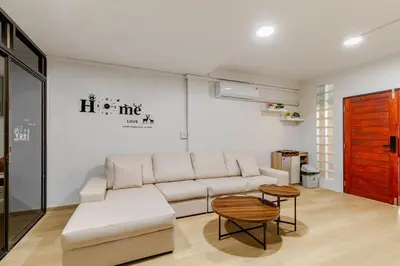 a living room with a white couch and a table at Cozy 5-story house, 2 mins walk BTS, BKK in Bangkok