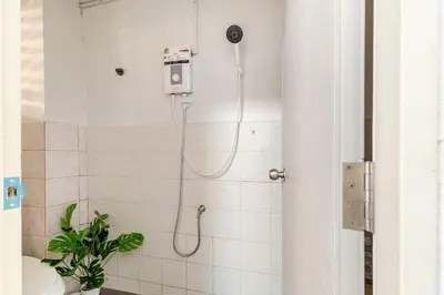 a bathroom with a shower with a phone on the wall at Cozy 5-story house, 2 mins walk BTS, BKK in Bangkok