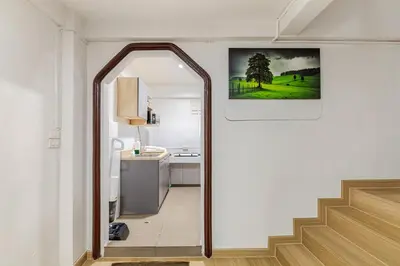 a hallway with a stairway leading to a kitchen at Cozy 5-story house, 2 mins walk BTS, BKK in Bangkok