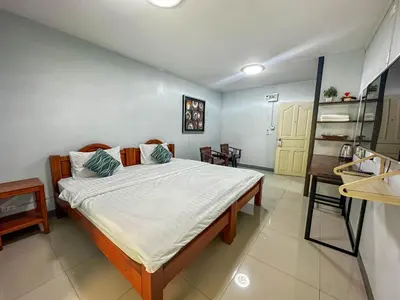a bedroom with a large bed in a room at Nuanchan Apartment in Ban O Pao