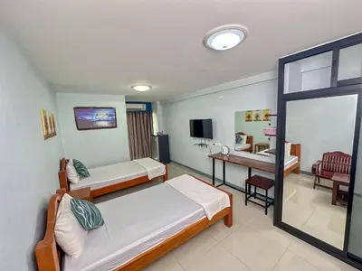 a hotel room with two beds and a desk at Nuanchan Apartment in Ban O Pao