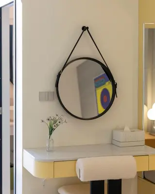 a mirror hanging on a wall above a desk at Bembis Hotel Charoenakorn 10 in Chinatown