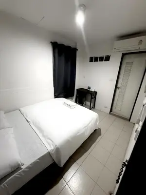 a large white bed in a room with a table at xxzNAP - Khaosan Road สแนป ตรอกข้าวสาร in Bang Bua Thong Railway Station