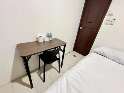 a small table with two cups on it next to a bed at xxzNAP - Khaosan Road สแนป ตรอกข้าวสาร in Bang Bua Thong Railway Station