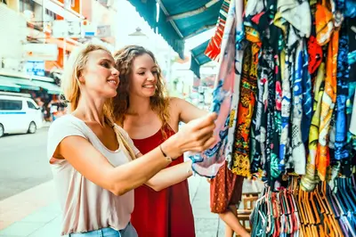 two women standing in front of a clothing store at xx zNAP - Khaosan Bangkok แนป ข้าวสาร กลางตรอกข้าวสาร in Bang Bua Thong Railway Station