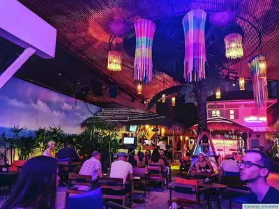 people sitting at tables in a restaurant with lights at xx zNAP - Khaosan Bangkok แนป ข้าวสาร กลางตรอกข้าวสาร in Bang Bua Thong Railway Station