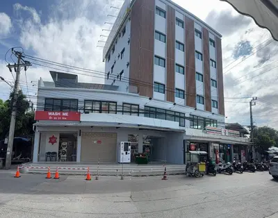 a large building on a street with cones in front of it at Nene Apartment in Ban Bang Talat