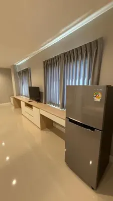 a room with a desk with a laptop and a refrigerator at Nene Apartment in Ban Bang Talat
