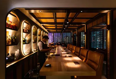 a man standing at a long table in a restaurant at XX SleepPOP Sukhumvit 42 - BTS Ekkamai Station - Bangkok in Phra Khanong