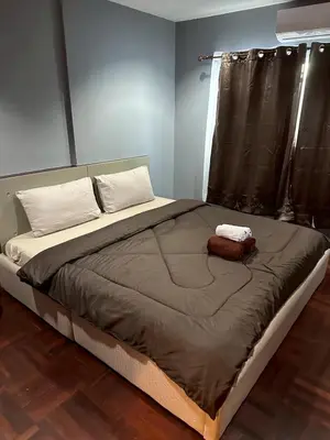 a large bed in a room with a window at MrchowRoom in Bangkok
