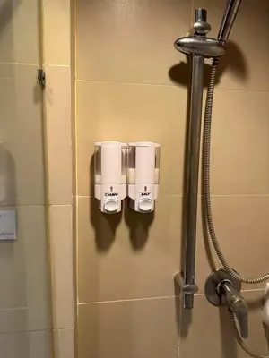 a bathroom with two soap dispensers on a wall at MrchowRoom in Bangkok