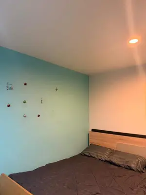 a bedroom with a bed and a blue wall at อุดมสุข BTS udomsuk in Bangna