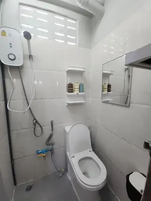a bathroom with a toilet and a shower at Sabai room in Taling Chan