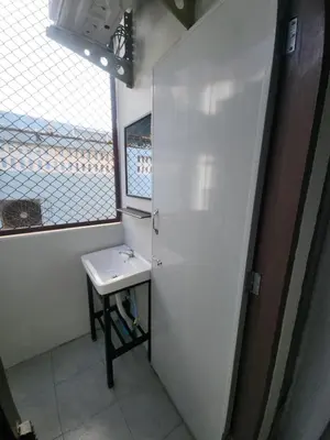 a small bathroom with a sink and a window at Sabai room in Taling Chan