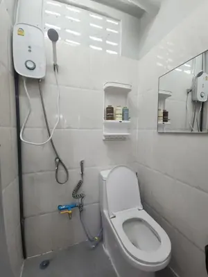 a bathroom with a toilet and a shower at Sabai room in Taling Chan