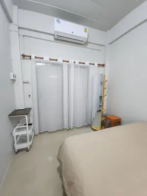 a bedroom with a bed and a air conditioner at Sabai room in Taling Chan