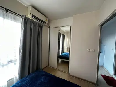 a bedroom with a mirror and a bed and a window at Plum condo Bang-yai station in Nonthaburi
