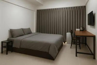a bedroom with a bed and a desk and a table at Hug14 Hotel in Ban Bang Toei (1)