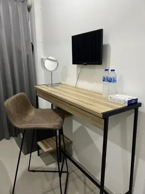 a desk with a television and two bottles of water at Hug14 Hotel in Ban Bang Toei (1)