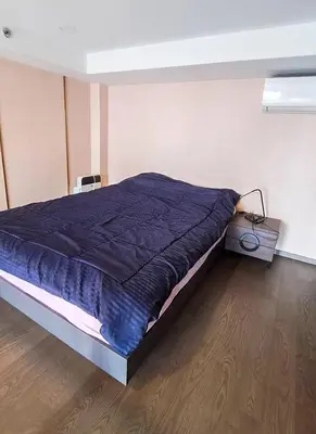 a bed with a blue comforter in a room at Luxury duplex condominium Samyan area 28th fl near MRT in Bangkok