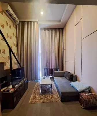 a living room with a couch and a tv at Luxury duplex condominium Samyan area 28th fl near MRT in Bangkok