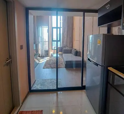 a kitchen with a sliding glass door to a living room at Luxury duplex condominium Samyan area 28th fl near MRT in Bangkok