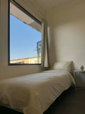a bedroom with a bed and a large window at Scandi Haus near ChinaTown in Bangkok