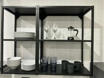 a black shelf with plates and glasses on it at Scandi Haus near ChinaTown in Bangkok