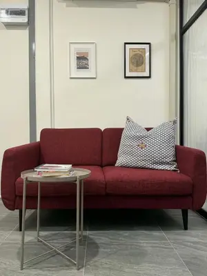a red couch in a room with a table at Scandi Haus near ChinaTown in Bangkok
