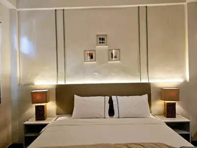 a bedroom with a large bed with two lamps at W House in Phra Khanong