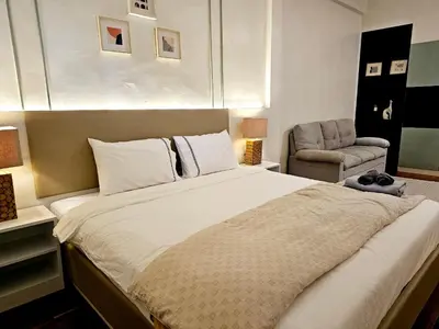 a bedroom with a large bed and a chair at W House in Phra Khanong