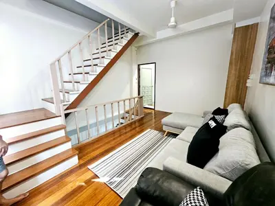 a living room with a couch and a staircase at W House in Phra Khanong