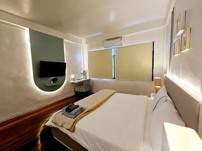 a bedroom with a white bed and a flat screen tv at W House in Phra Khanong