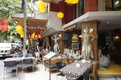 a restaurant with two statues of people sitting at tables at Taradii Boutique in Bangkok