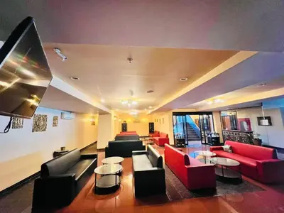 a large living room with couches and tables at NSC Apartel in Bangkok