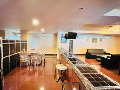 a living room with a bar and a dining room at NSC Apartel in Bangkok