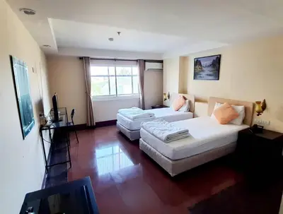 a living room with two beds and a couch at NSC Apartel in Bangkok