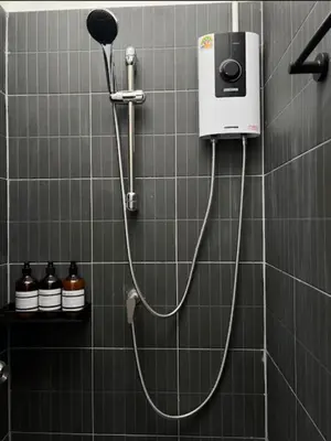 a shower with a blow dryer on a wall at Bongo Residence Ratchathewi Bangkok in Bangkok