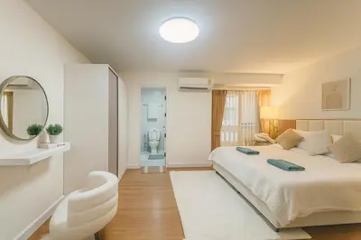 a bedroom with a large bed and a mirror at Cozy Designer Apartment - Sukhumvit 39 in Bangkok