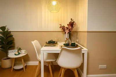 a white table with chairs and a vase of flowers at Cozy Designer Apartment - Sukhumvit 39 in Bangkok