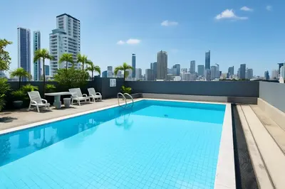 a swimming pool on top of a building with a city skyline at Cozy Designer Apartment - Sukhumvit 39 in Bangkok