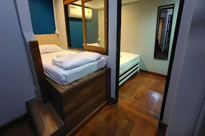 a small room with a bed and a mirror at Pratunam Family House in Ban Nong Chaeng