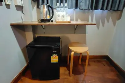 a trash can sitting next to a table and a stool at Pratunam Family House in Ban Nong Chaeng