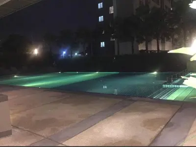 an empty swimming pool at night with green lights at Lumpini nawamin in Ban Bang Toei (1)