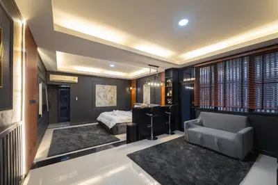 a bedroom with a bed and a couch in a room at Delta 9 Phrakanong in Bangkok