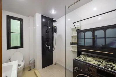 a bathroom with a glass shower and a toilet at Delta 9 Phrakanong in Bangkok