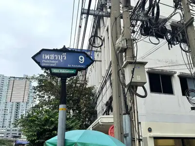 a blue street sign on a pole next to a building at Sonata siam-ratchathewi in Bangkok