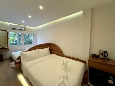 a hotel room with two beds and a television at Sonata siam-ratchathewi in Bangkok