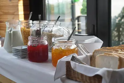 a table topped with jars of jam and bread at iSanook Hostel in Bangkok